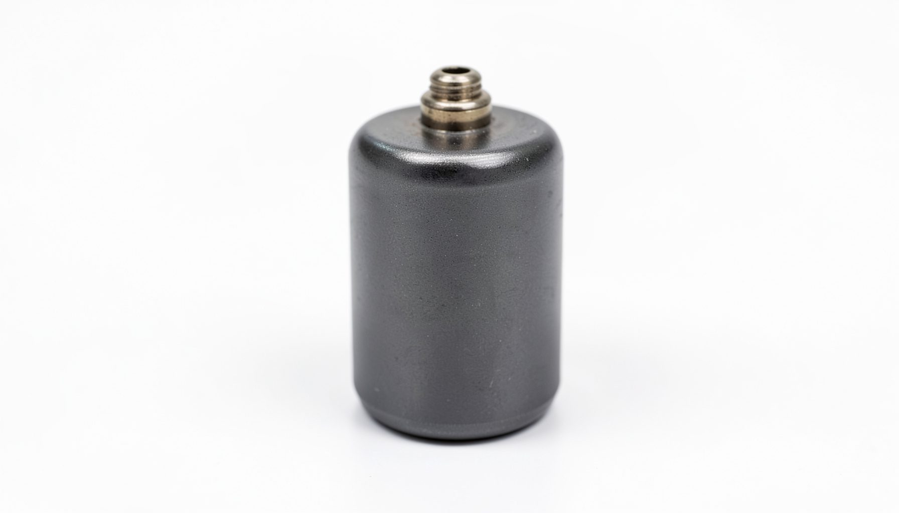 Close-up of a dark grey electrochemical cell with subtle metallic sheen, set against a clean white laboratory background.